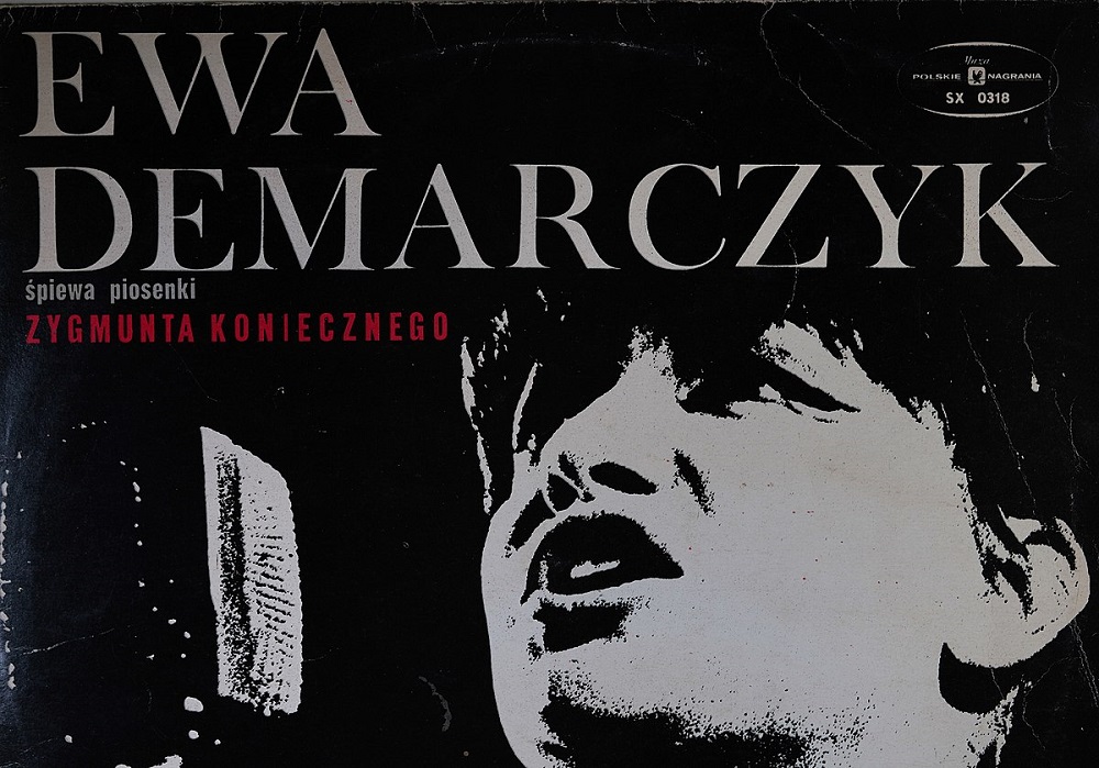 A black and white portrait of Ewa Demarczyk with white text reading "EWA DEMARCZYK"