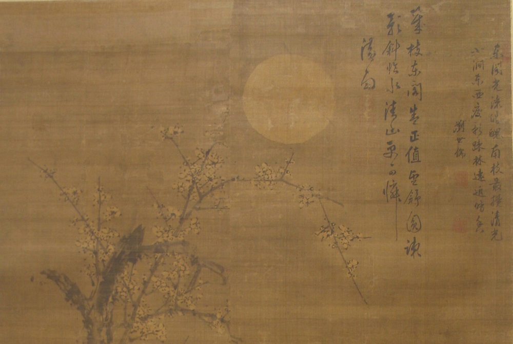 painting of a flowered branch, a sun, and some Chinese characters on what looks like a beige tapestry.