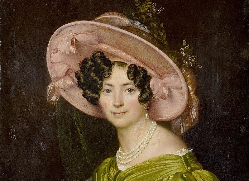 Painted portrait of Volkonskaya. She wears a yellow-green silk dress, a pearl necklace, and a pink hat. Her brown hair is in tight curls around her face.
